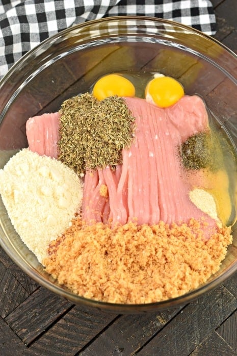 Ingredients needed for turkey meatballs in a glass bowl.
