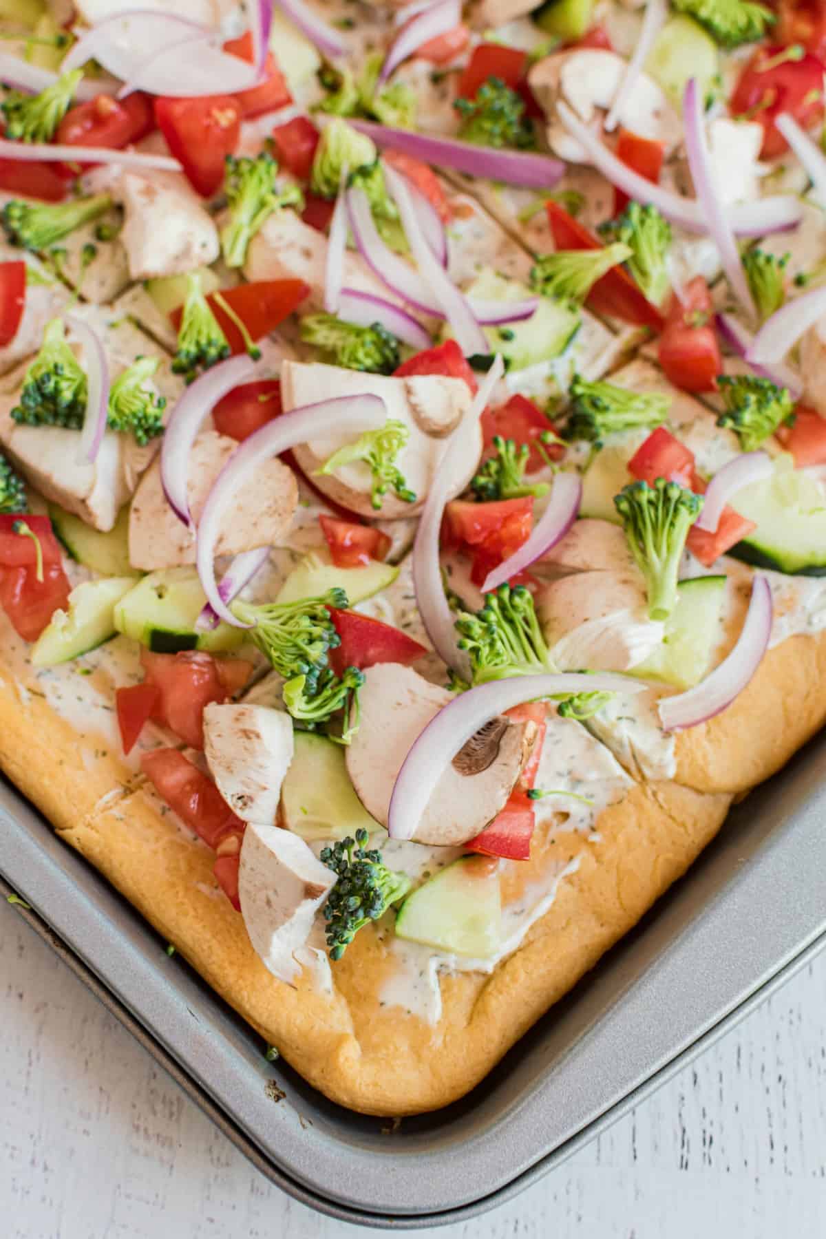 Baking sheet with a cold veggie pizza.