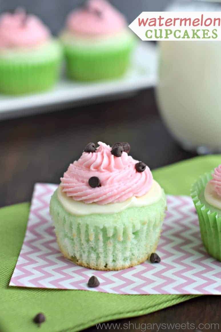Green cupcake topped with white chocolate and pink watermleon frosting. chocolate chips sprinkled on top to resemble a watermelon.