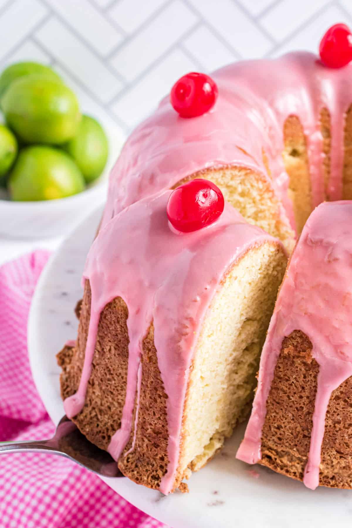 Slice of cherry pound cake being removed from plate.