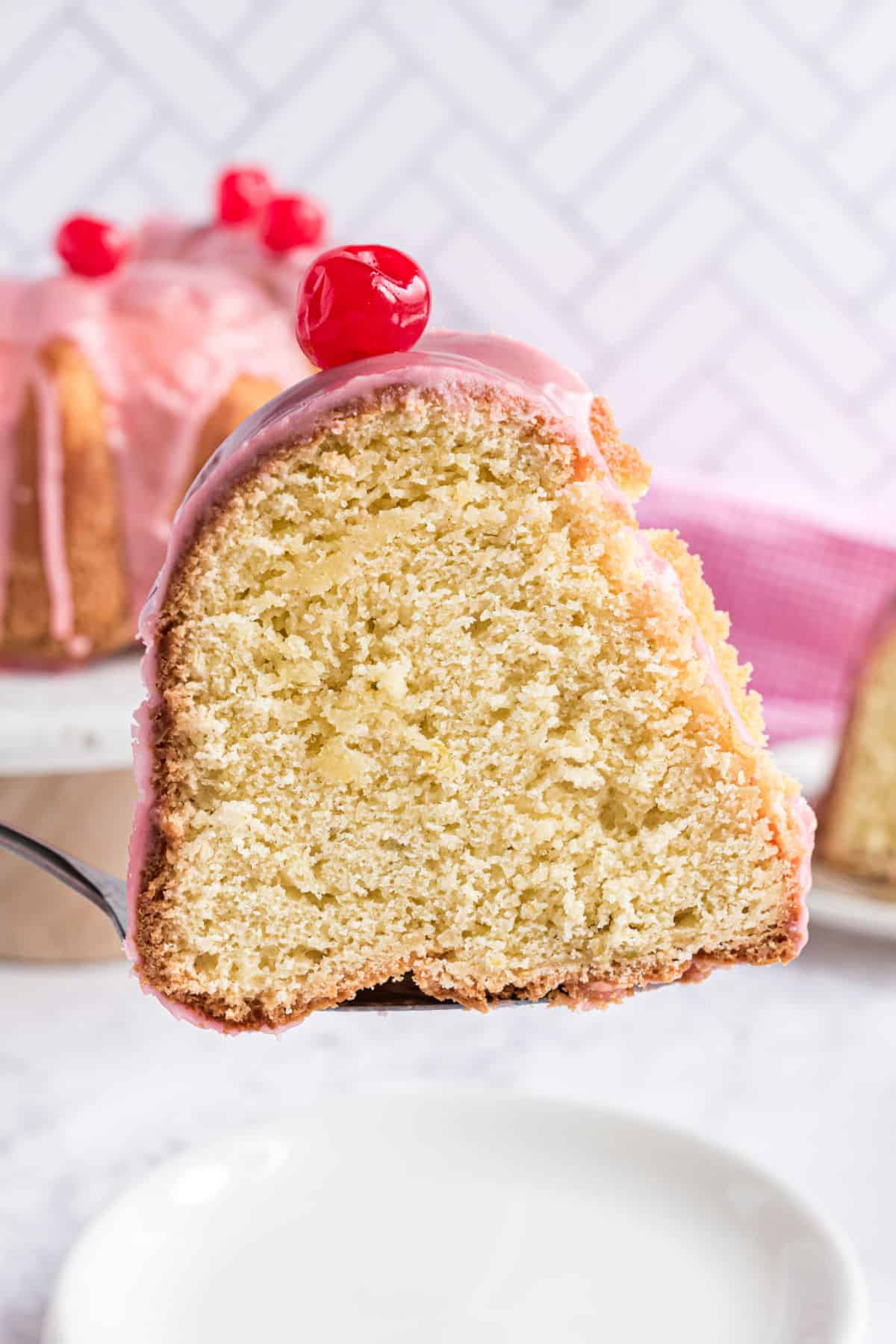 Slice of cherry margarita pound cake being served on a white plate.