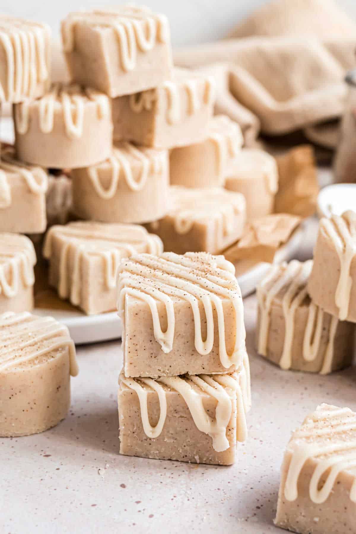 Pieces of cinnamon fudge stacked on parchment paper.