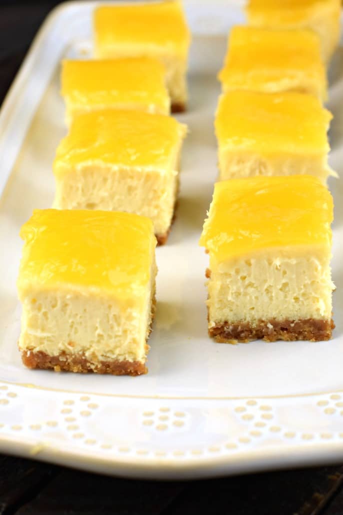 Bites of lemon cheesecake on a white plate.