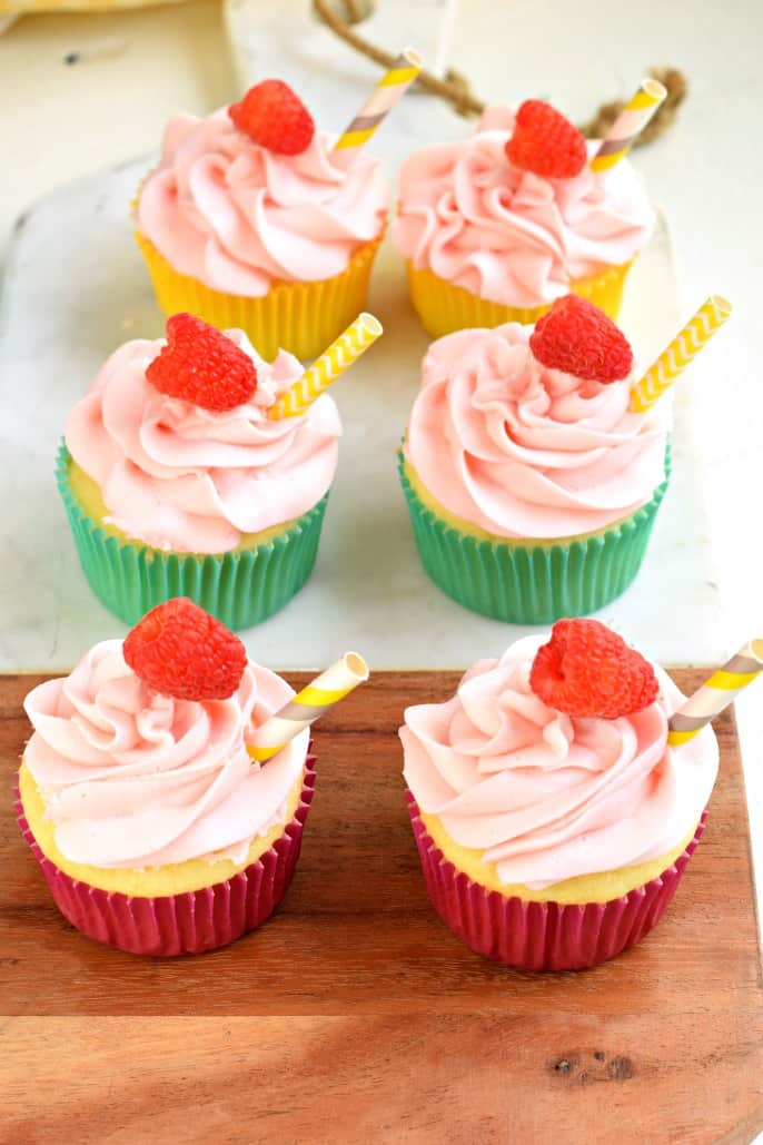 Raspberry Lemonade cupcakes with fresh raspberries and straws.