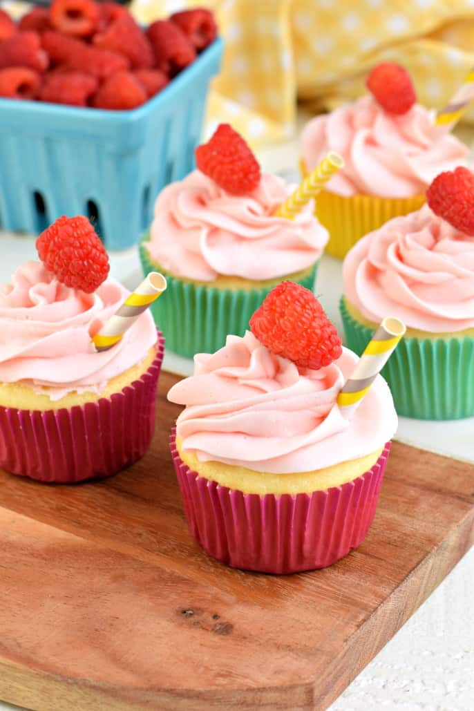 Lemonade cupcakes with raspberry frosting and fresh raspberry garnish.