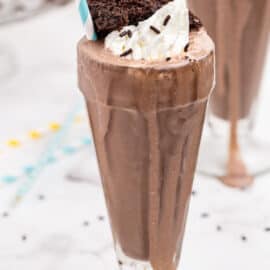 Chocolate milk shake with chocolate cake and whipped cream in sundae glass.