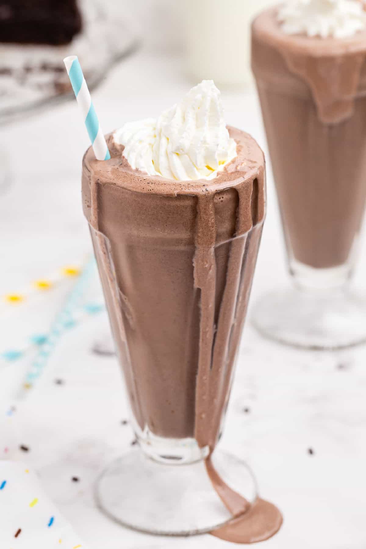 Chocolate cake shake in a sundae glass with whipped cream.