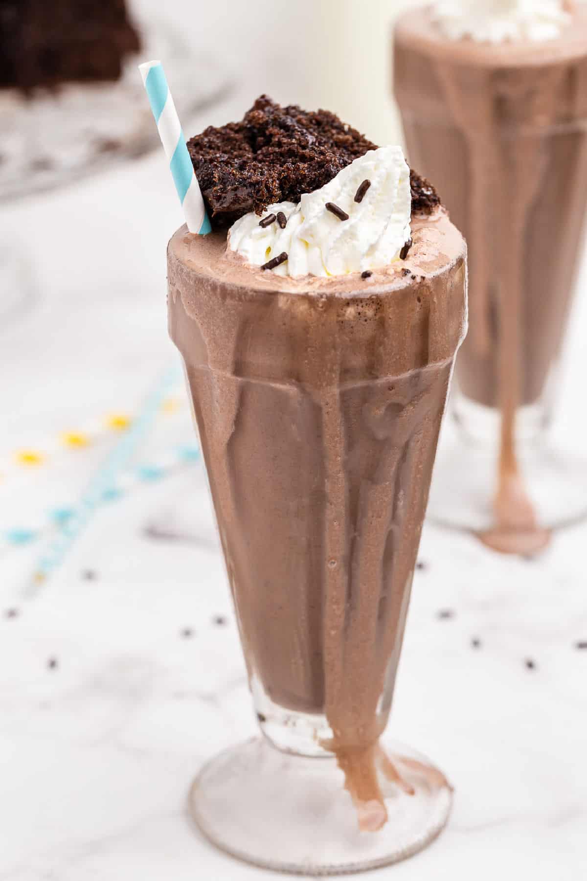 Chocolate milk shake with chocolate cake and whipped cream in sundae glass.