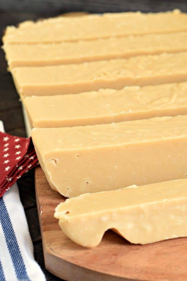 Block of peanut butter fudge cut into strips on cutting board