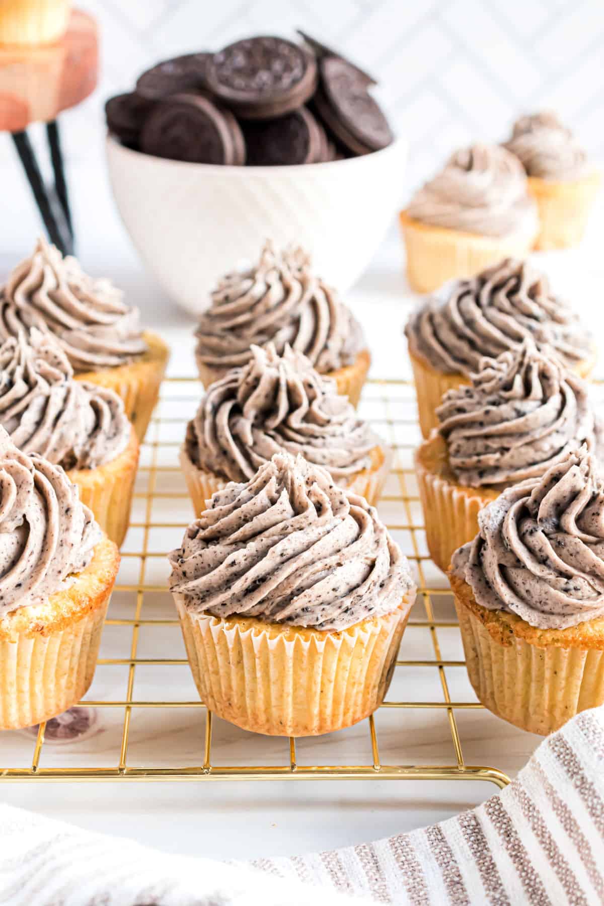 Oreo cupcakes on a gold cooling rack.