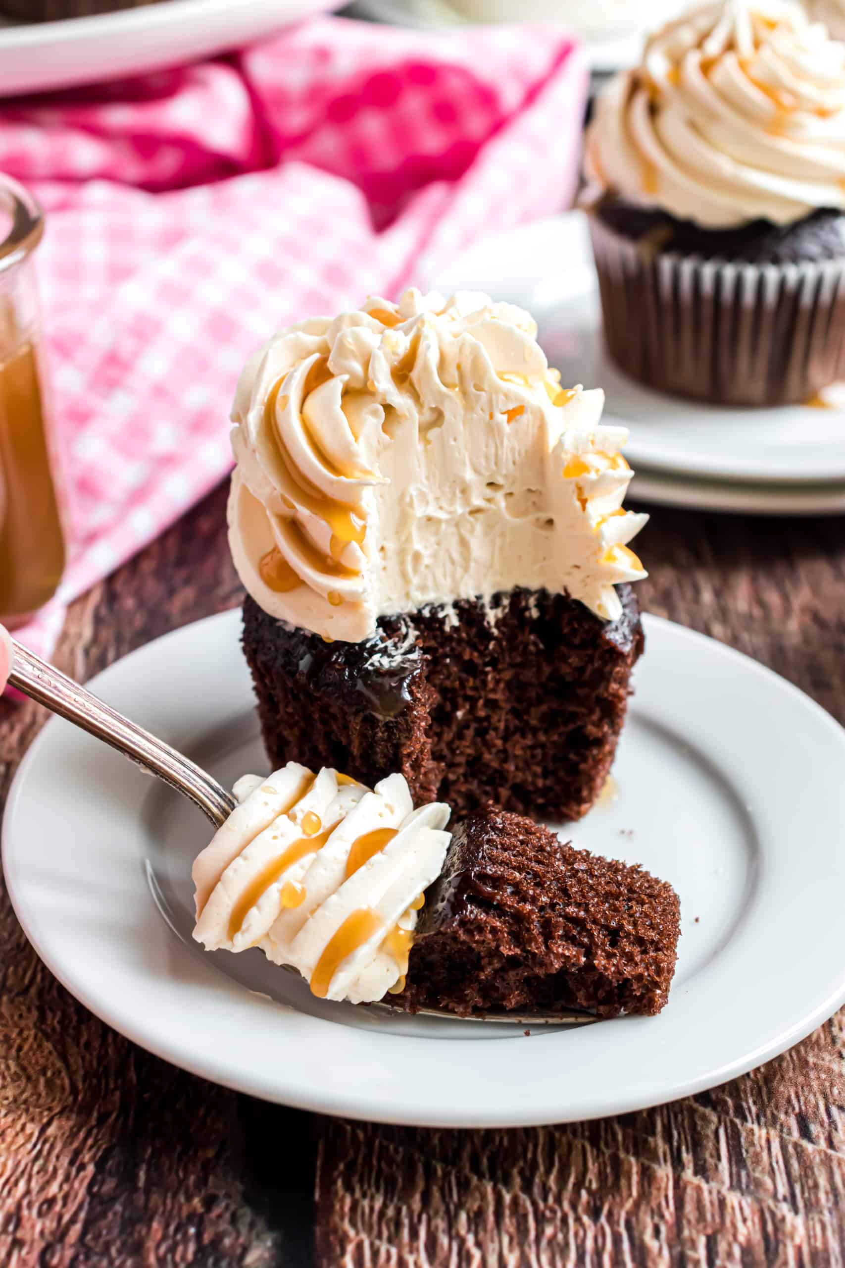 Chocolate cupcake with swiss meringue frosting and bite taken out.