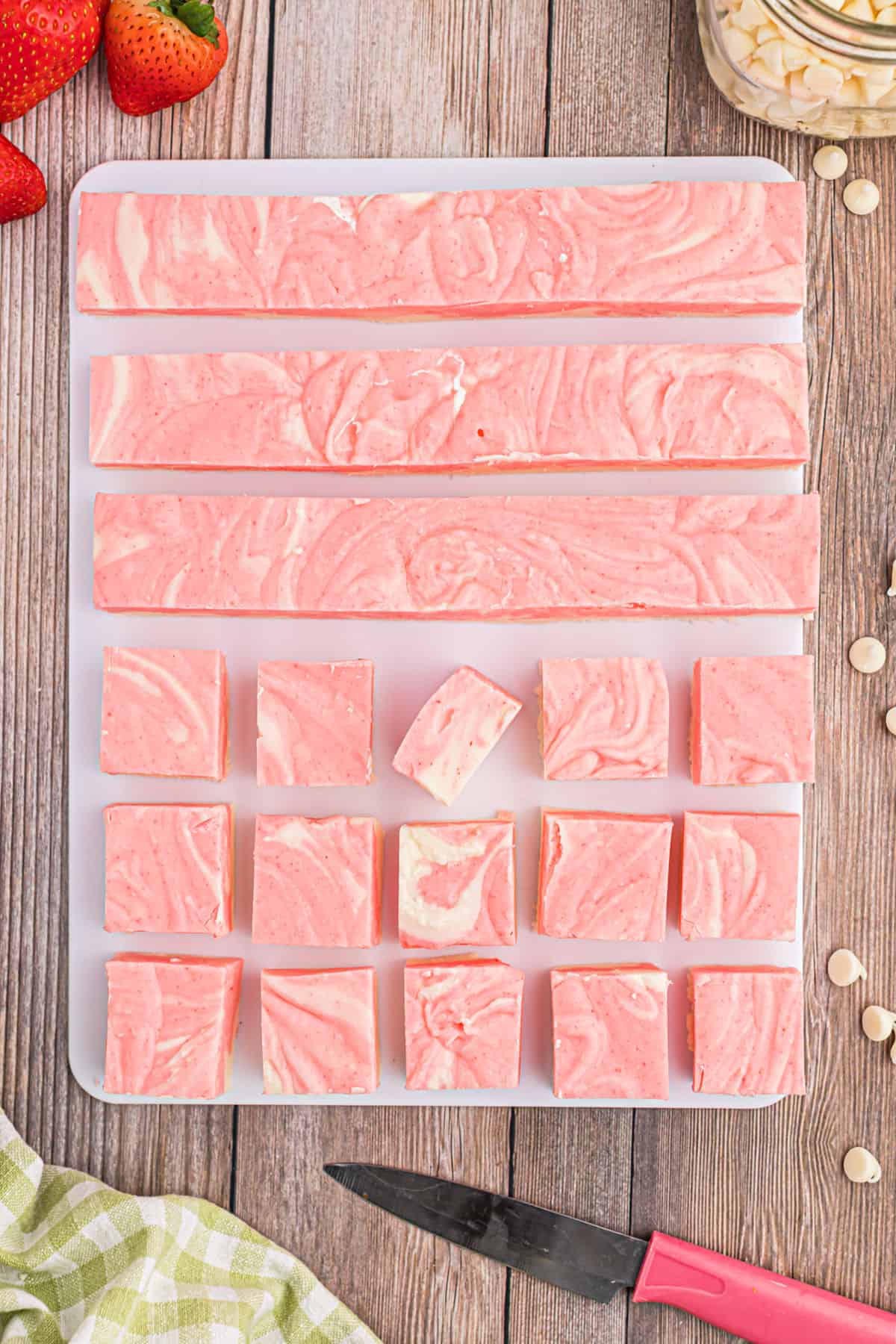 Pieces of strawberry swirl fudge on parchment paper.