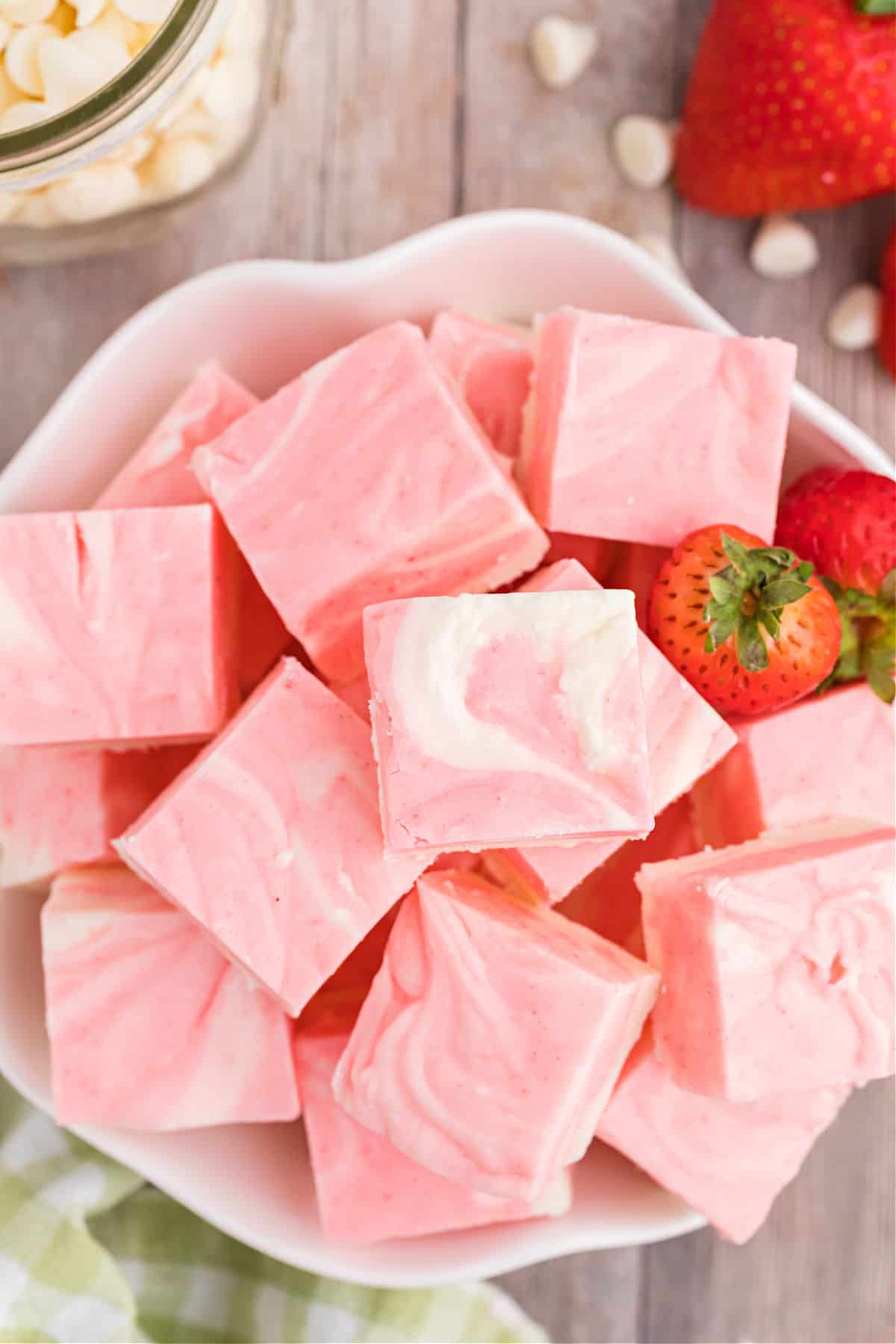 Pieces of strawberry fudge in a white bowl.