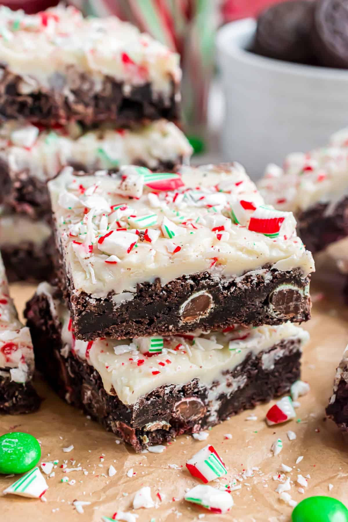 Stack of chocolate cookie bars with candy cane white fudge topping.