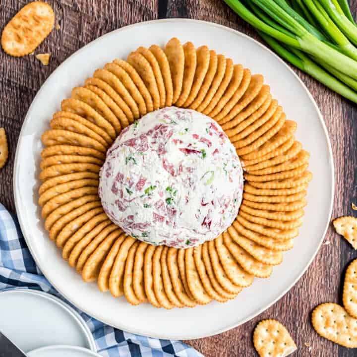 Chipped beef cheese ball served on a plate with townhouse crackers.