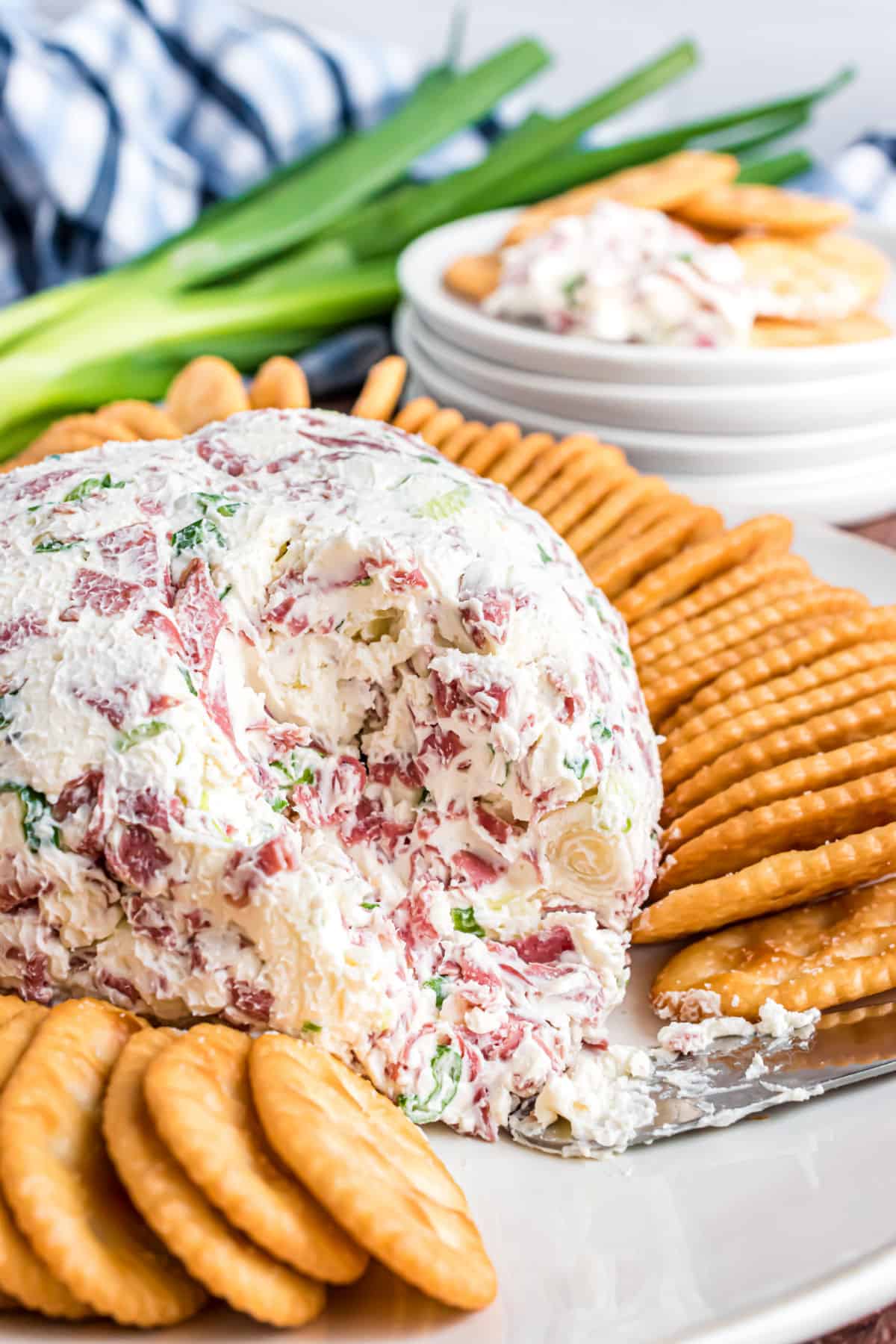 Chipped beef cheese ball with a scoop removed and served with crackers.