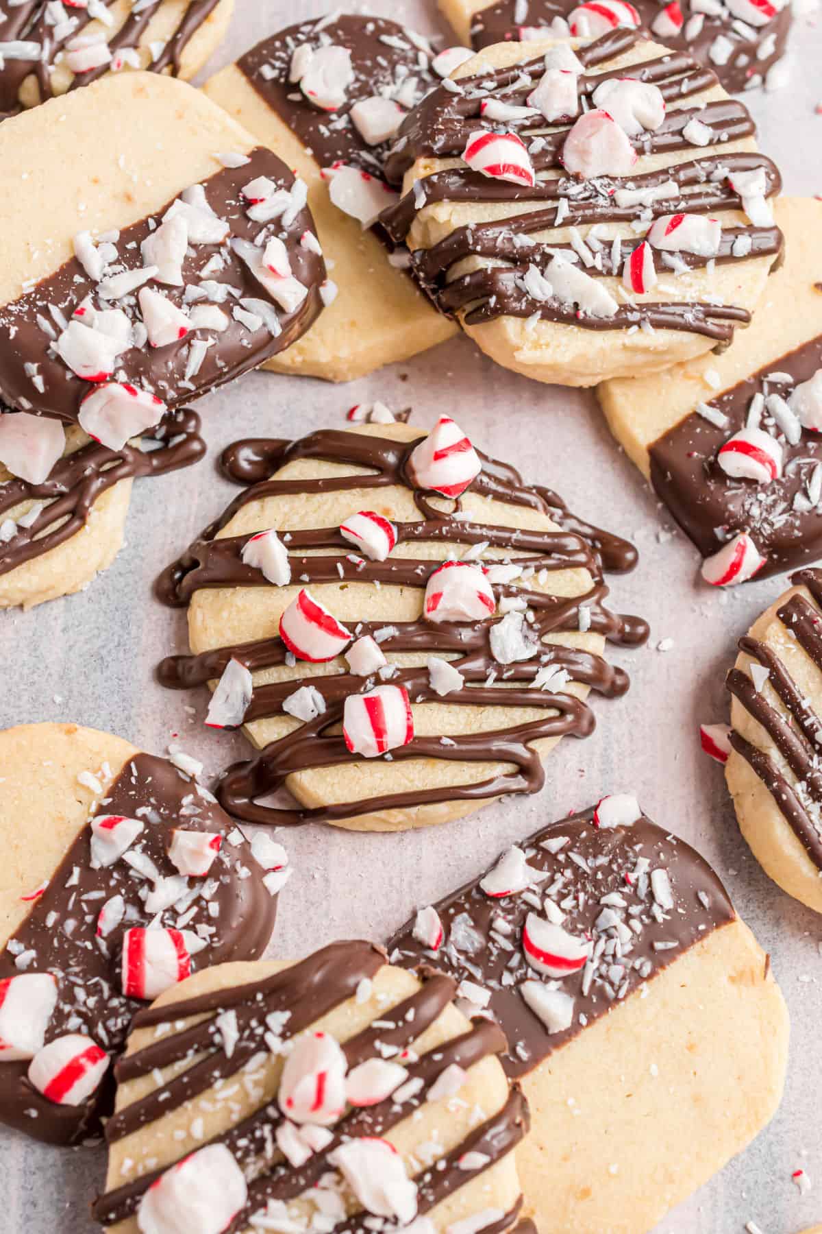 Shortbread cookies with chocolate and peppermint on parchment paper.