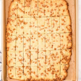 Butterscotch shortbread cookie bars on parchment paper lined baking sheet.