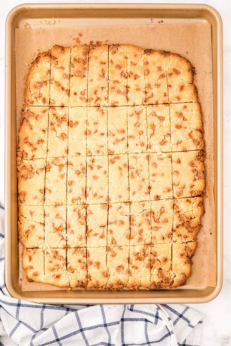 Butterscotch shortbread cookie bars on parchment paper lined baking sheet.