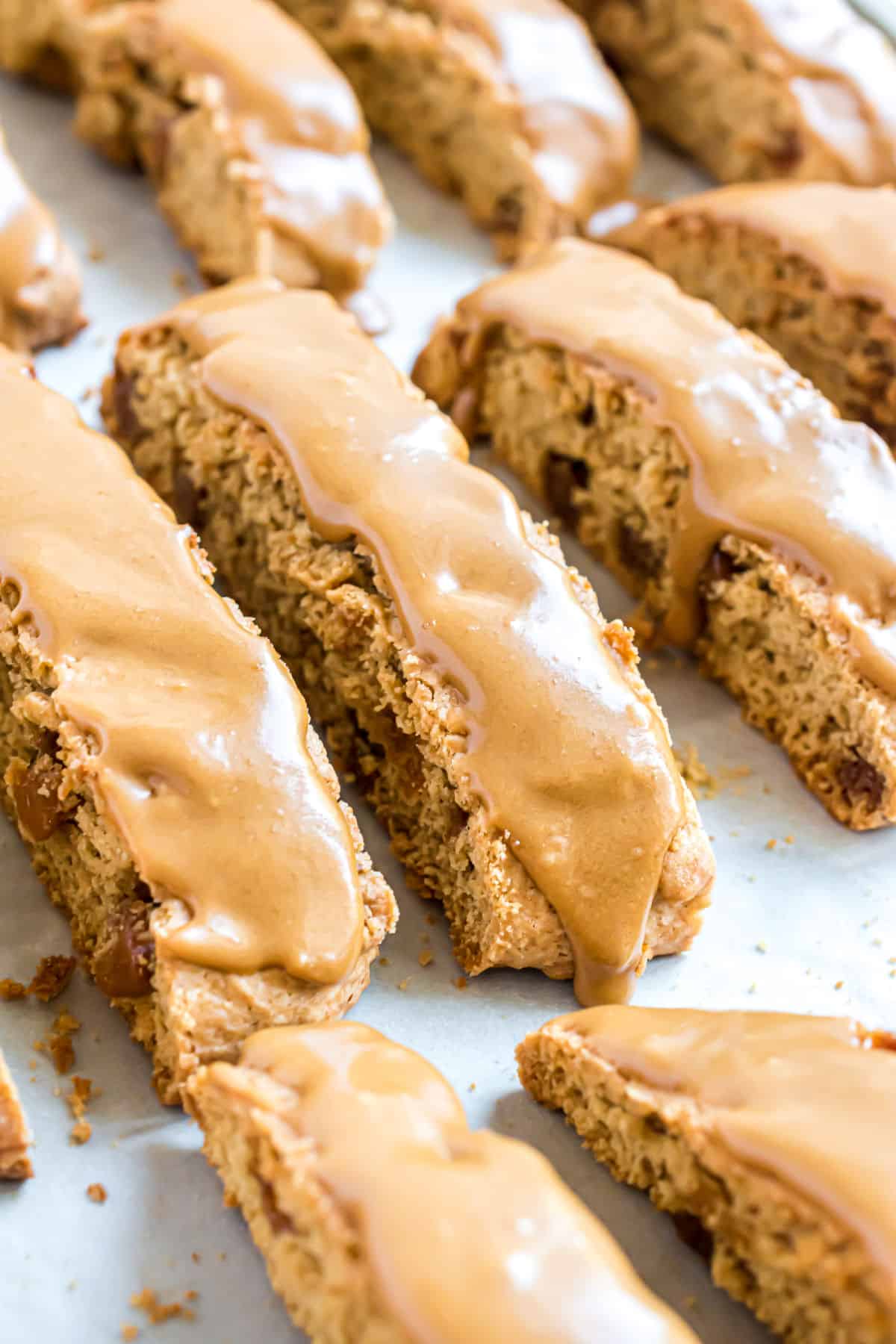 Caramel topped biscotti on a parchment paper lined cookie sheet.