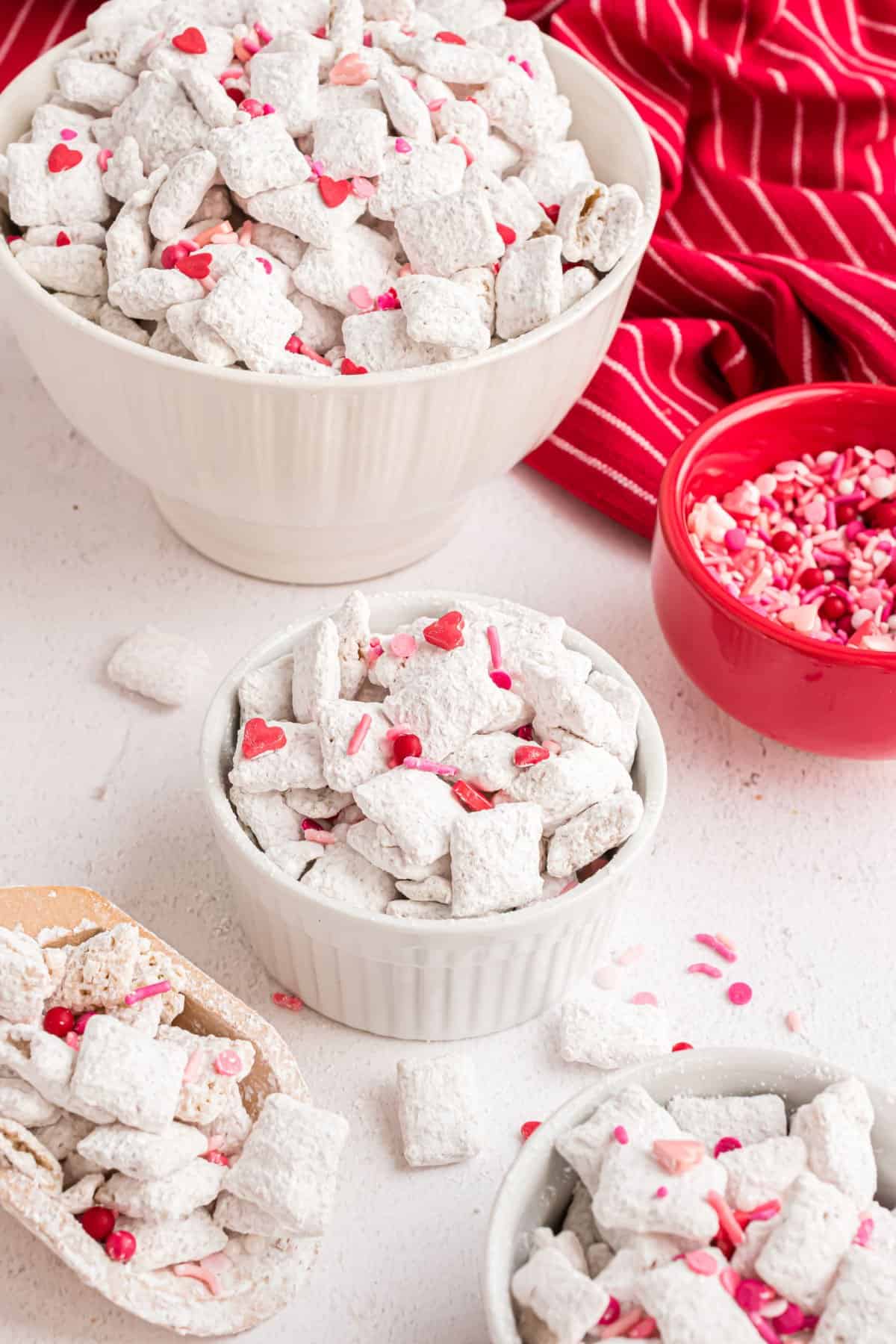 Puppy chow with Valentine sprinkles served in white bowls.