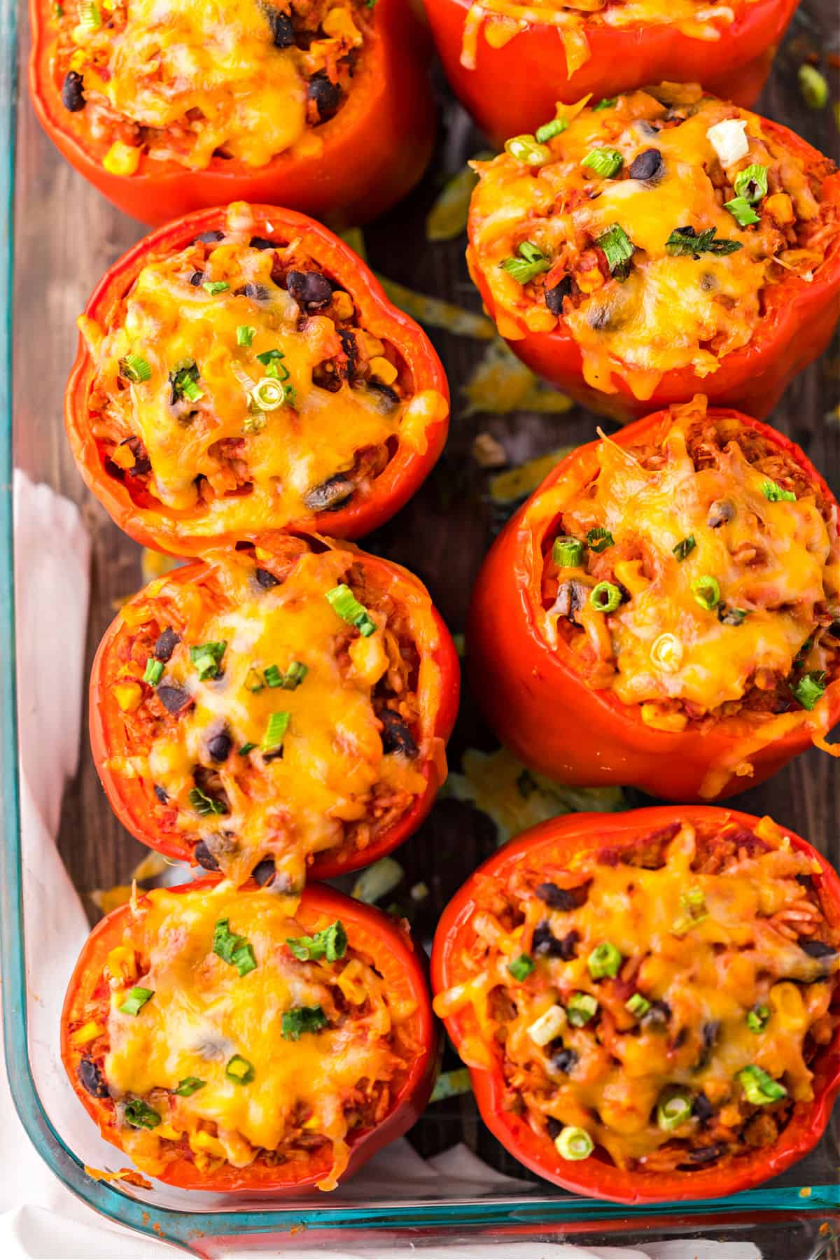 Stuffed red peppers in a clear glass 13x9 baking dish.