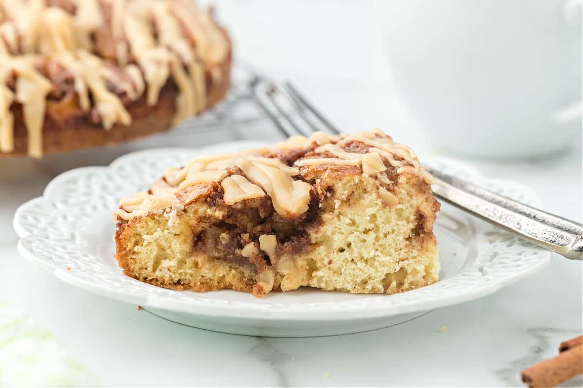 Slice of apple coffee cake on white plate.