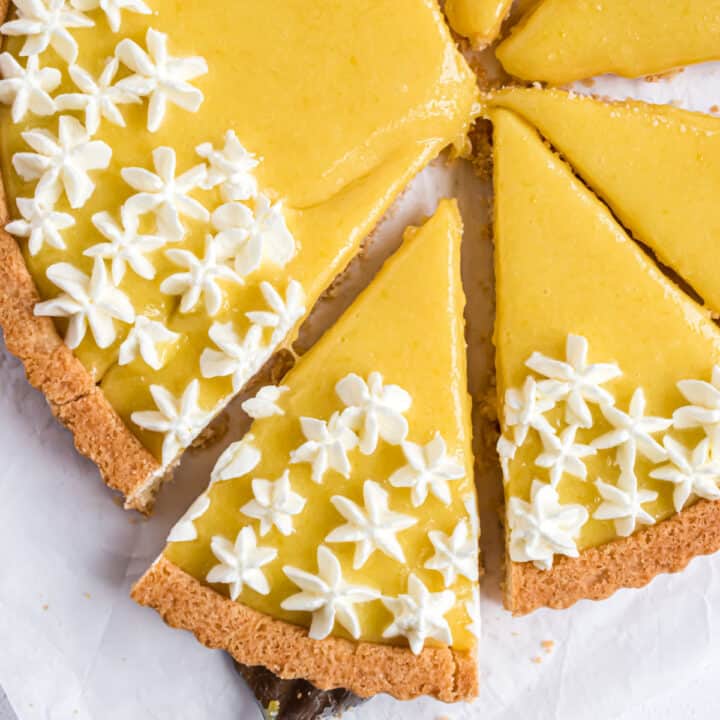Lemon tart cut into 8 slices and topped with whipped cream.