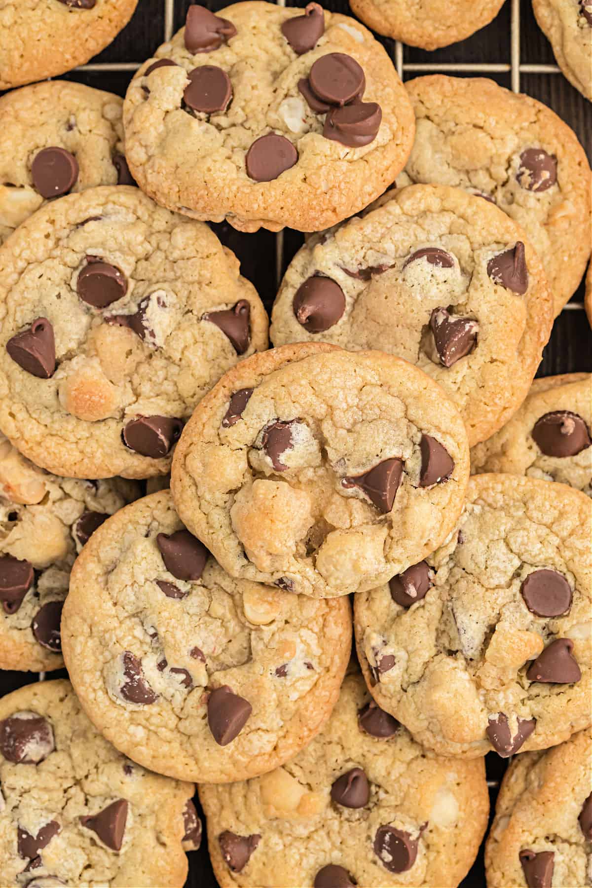 Macadamia chocolate chip cookies stacked on a wire cooling rack.