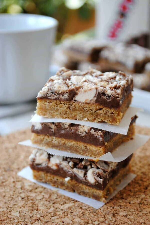 Stack of three whopper cookie bars on parchment paper.