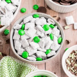 Mint puppy chow in a white bowl with green M&Ms.