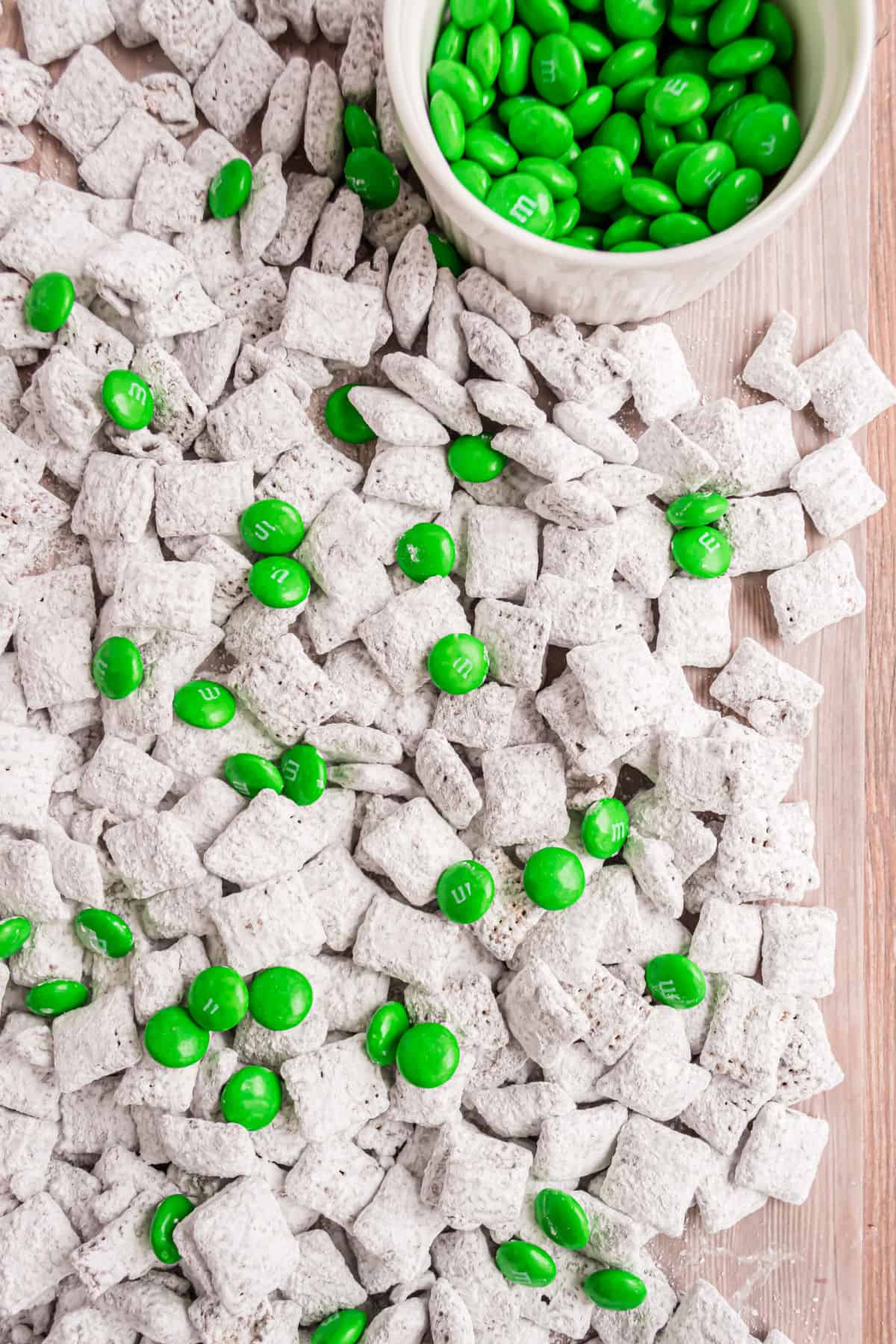 Mint puppy chow spread on parchment paper to set.