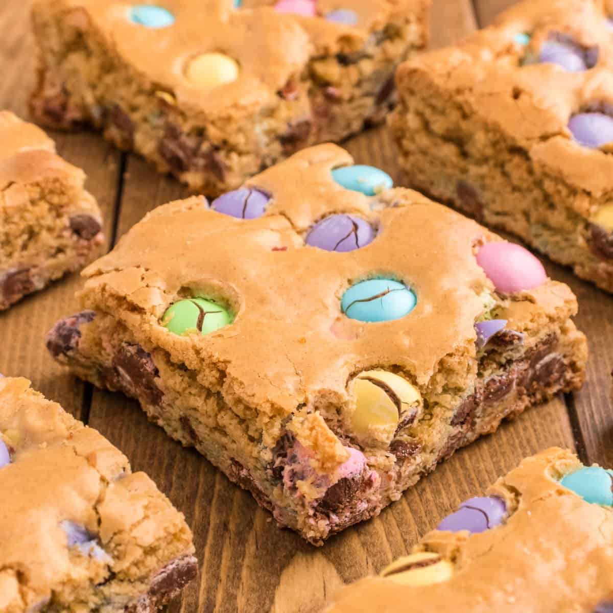 Thick blondies cut into squares with pastel candy.