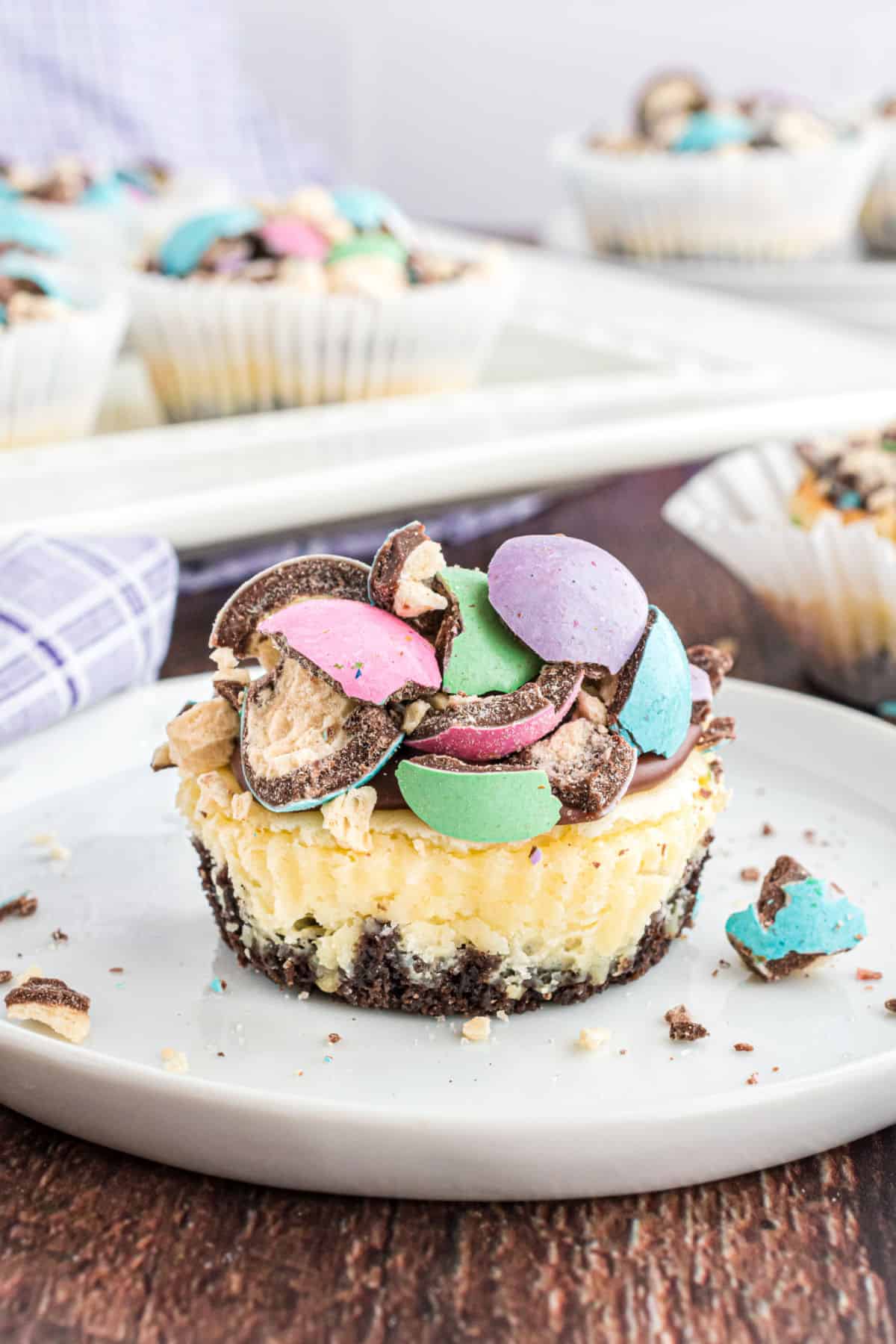 Mini cheesecakes topped with ganache and colored malt balls.