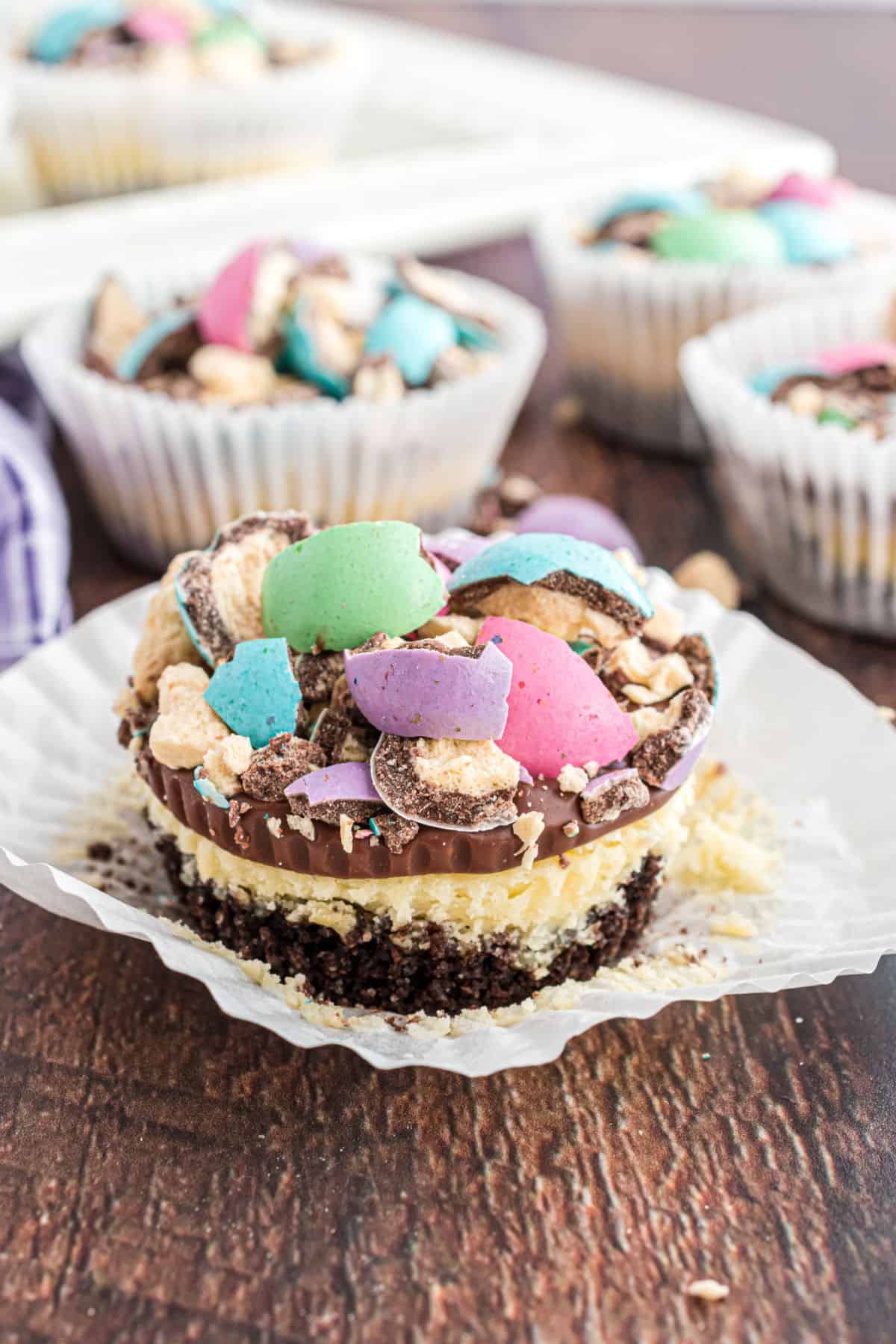 Mini cheesecake topped with chocolate ganache and malt ball candy.