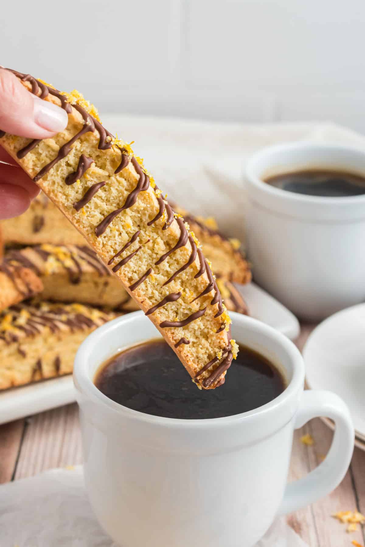 Orange biscotti dunked in hot coffee.