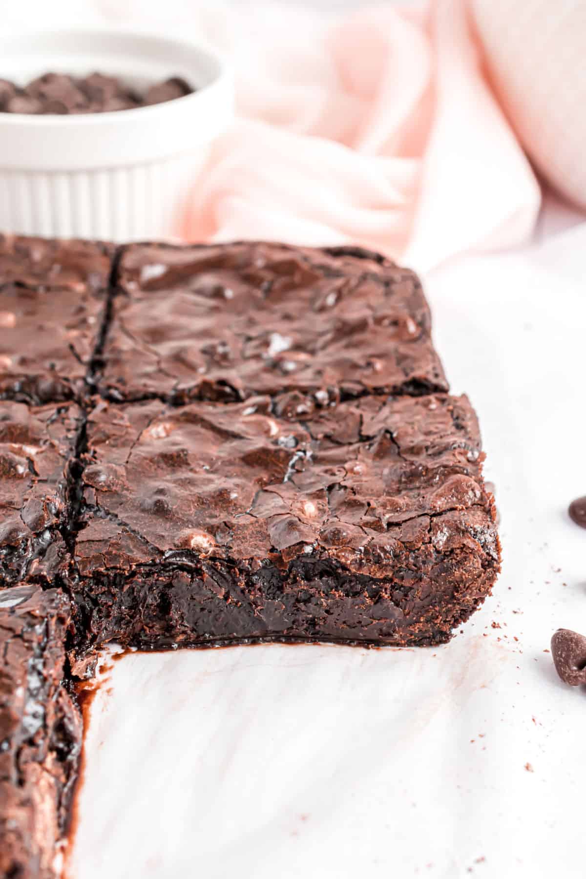 Fudgy dark chocolate brownies on parchment paper.