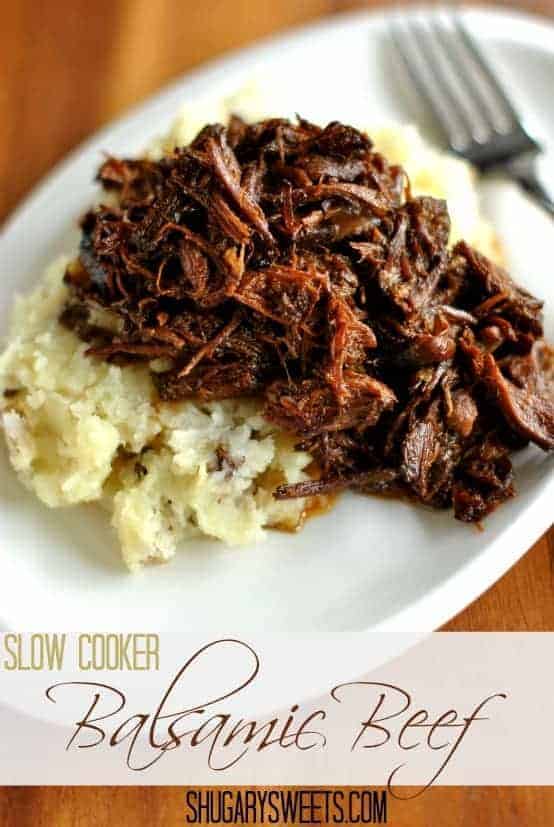 Shredded beef over a pile of smashed potatoes on a white plate.
