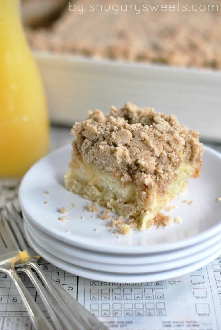 Coffee cake with cheesecake filling and thick streusel on a stack of white dessert plates.