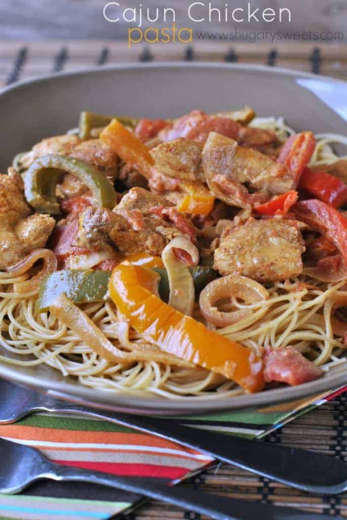 Big gray bowl of cajun chicken pasta with sliced peppers and onions.