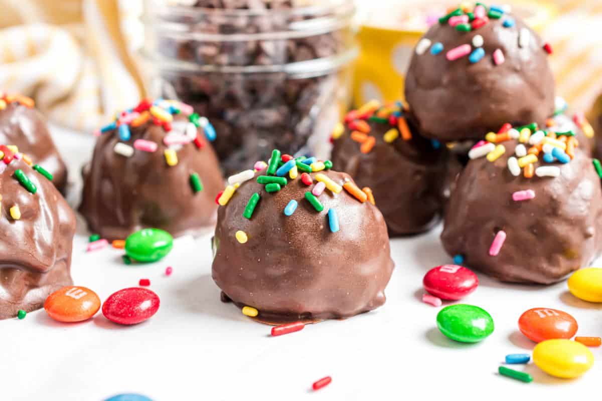Monster cookie dough truffles dipped in chocolate and topped with sprinkles.