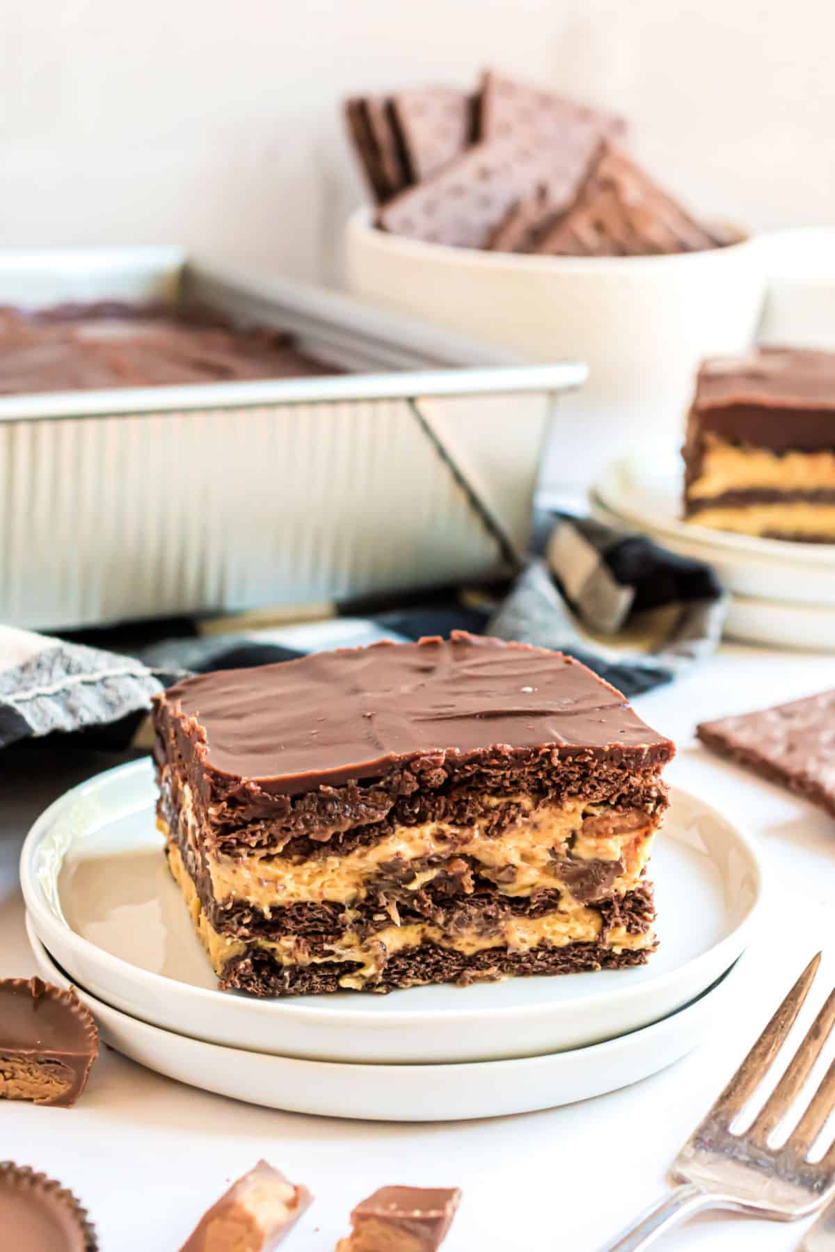 Layered peanut butter and chocolate dessert on a white plate.