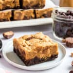 Peanut butter brookies on white plate with stack behind.