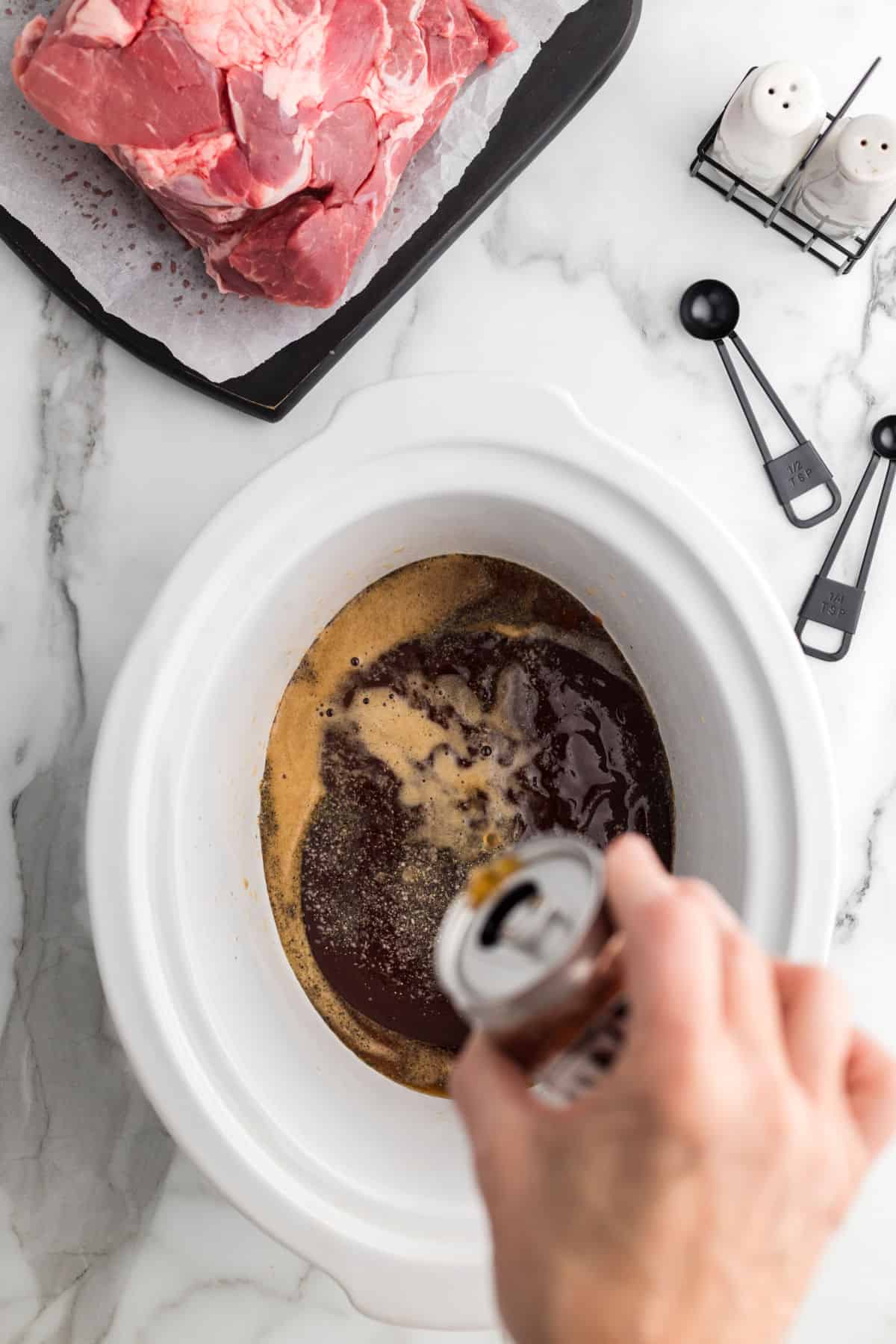 Root beer being added to slow cooker for pulled pork.