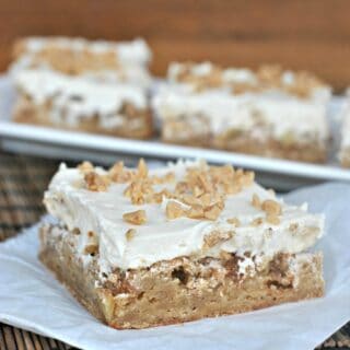 Apple blondies with caramel buttercream, on a piece of parchment paper.