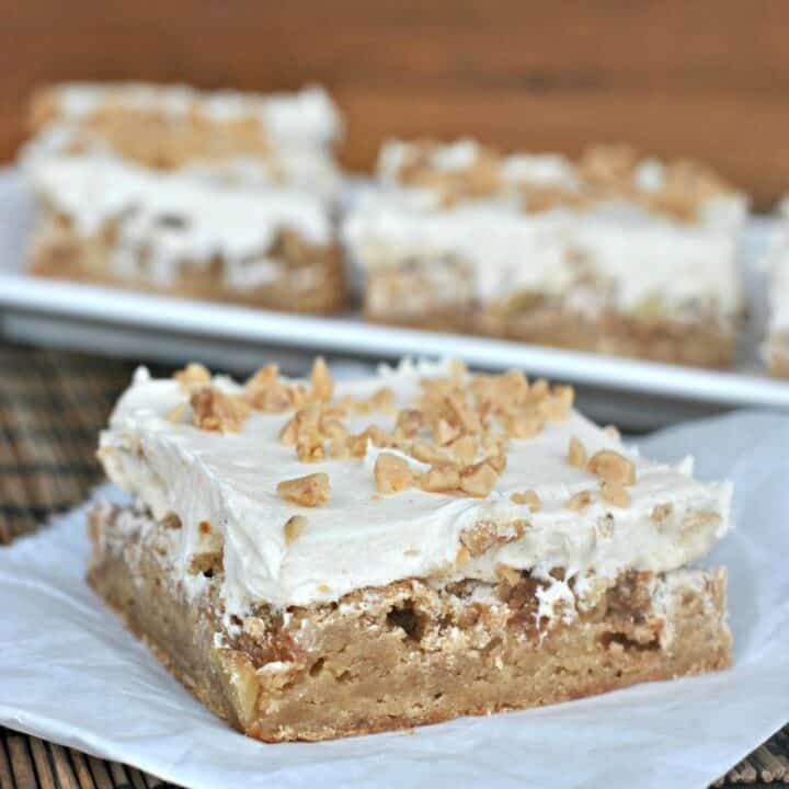 Apple blondies with caramel buttercream, on a piece of parchment paper.