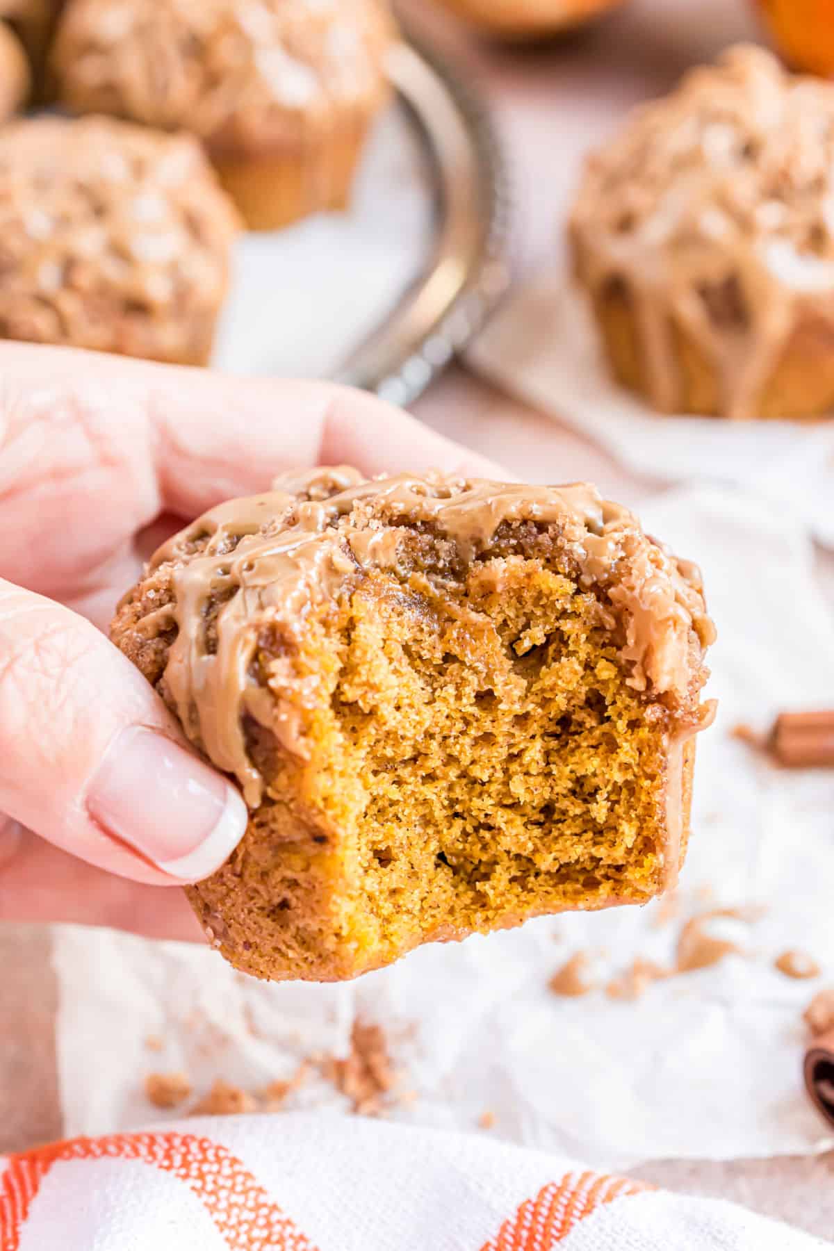 Maple glazed pumpkin muffin with a bite taken.