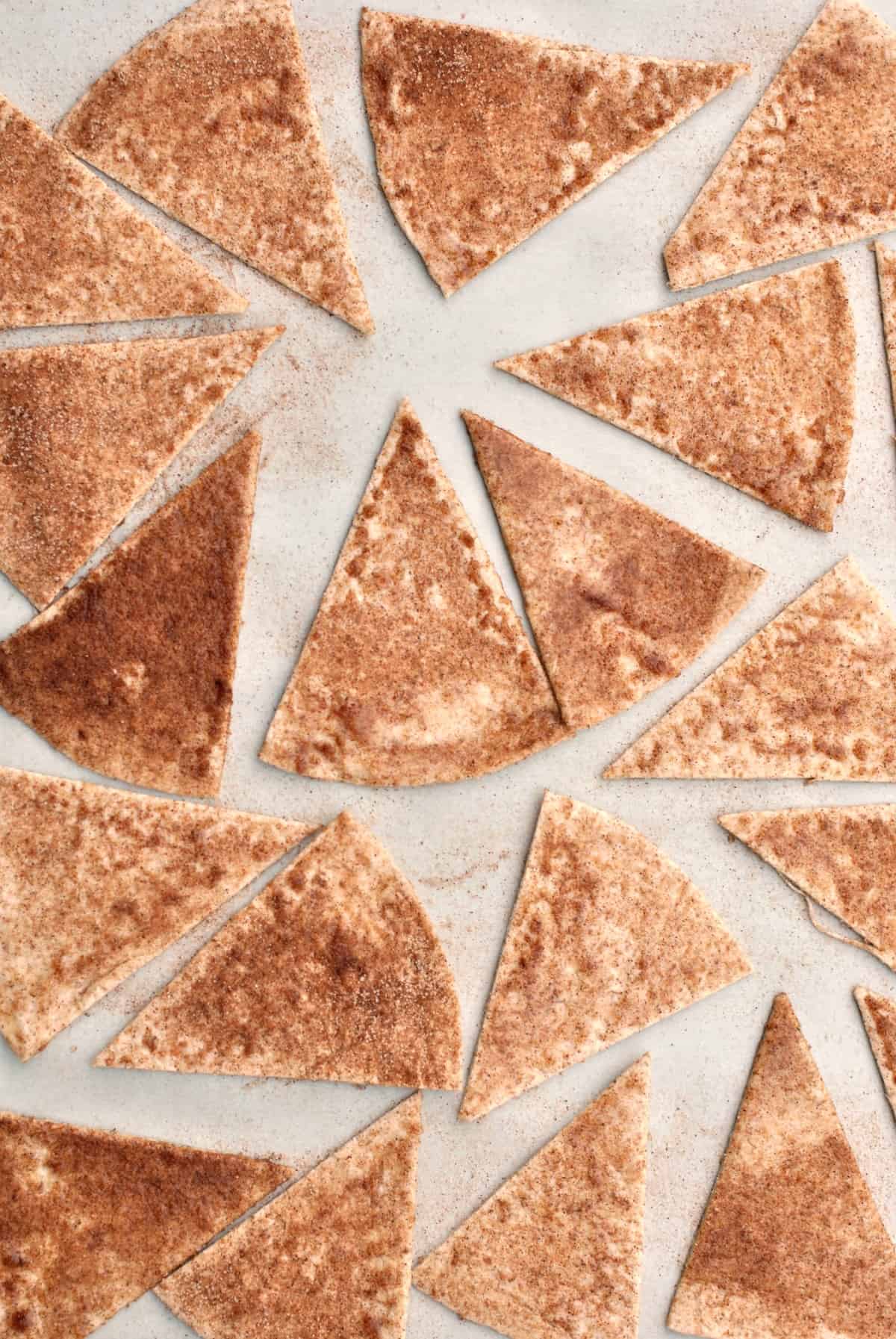 Cinnamon sugar tortilla chips on a baking sheet.