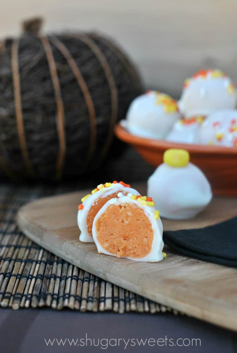 Candy corn oreo truffle cut in half to reveal orange center,