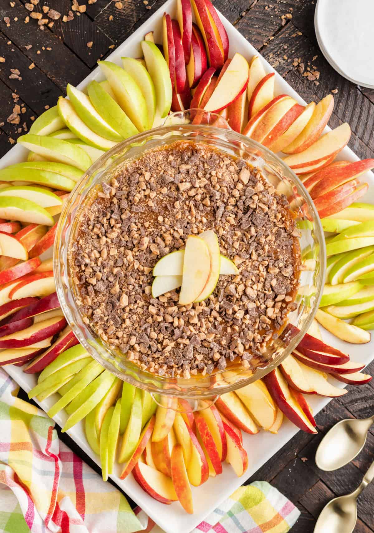 Caramel apple dip in pie plate with sliced apples for serving.